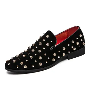 Heren instappers met spitse neus in zwart versierd met gouden studs en metalen bloemen
