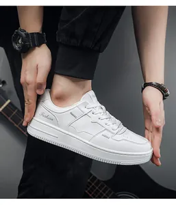 Close-up van witte leren lage sneakers gedragen door een model in een trendy casual stijl.