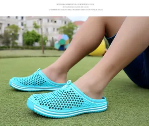 Vue lifestyle de sandales d'été ajourées bleu cyan respirantes sur l'herbe verte