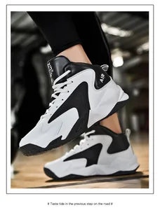 Close-up view of black and white high-top basketball shoes being worn on foot outdoors.