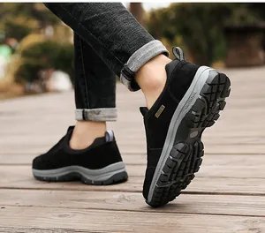 Nahaufnahme von schwarzen Outdoor-Wanderschuhen zum Reinschlüpfen auf einem Holzweg.
