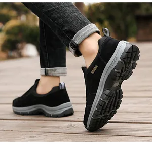 Nahaufnahme von schwarzen Herren-Outdoor-Slippern mit dicker Profilsohle auf einem Holzweg