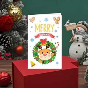 Carte de vœux de Noël festive avec un renne mignon posée sur une boîte cadeau rouge