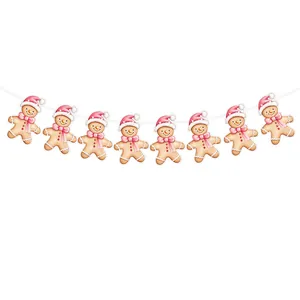 Watercolor gingerbread man Christmas bunting garland with pink bows and Santa hats for party