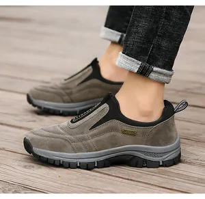 Nahaufnahme der braunen Wildleder-Slipper für Herren auf einem Holzdeck