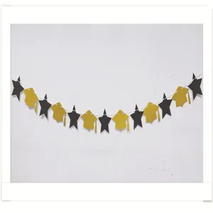 Macro view of gold glitter graduation cap and black star banner for party decoration