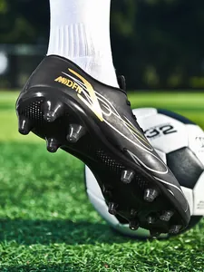 Vue détaillée de la semelle des crampons de football noirs sur terrain d'herbe