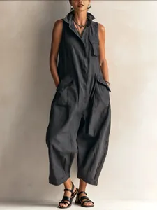 Full length view of a woman wearing a black vintage cargo jumpsuit with multi-pockets