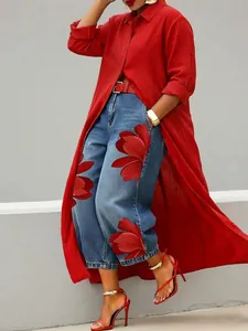 Close-up detail of stylish long red button-up shirt and floral print denim jeans set