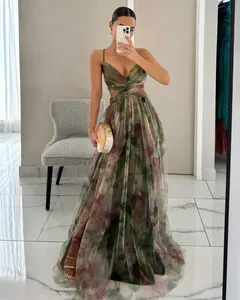 Full-length view of an elegant mesh printed maxi dress with spaghetti straps and cut-out detail