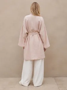 Back view of a loose-fit pink linen trench coat with a belt for women's fashion.