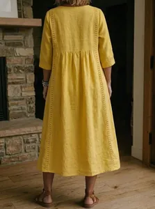 Detailed back view of a yellow loose cotton linen midi dress with delicate lace trim