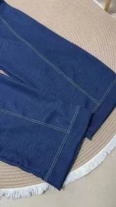 Close-up of deep blue cotton linen wide-leg jumpsuit with white contrast stitching