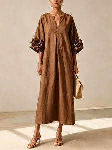 Close-up detail of brown French style loose cotton linen dress with 3D flower sleeves.
