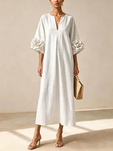 Detailed view of a white cotton linen dress featuring elegant 3D floral sleeves