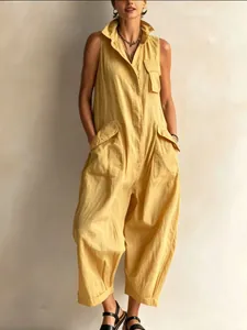 Detailed view of yellow sleeveless utility jumpsuit with stand-up collar and wide legs
