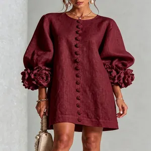 Detailed view of 3D floral accents on lantern sleeves of a burgundy linen dress