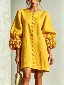 Detail of yellow French dress featuring 3D floral accents on lantern sleeves