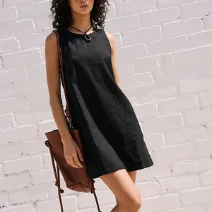 Detailed view of a black cotton linen sleeveless mini dress worn by a model outdoor