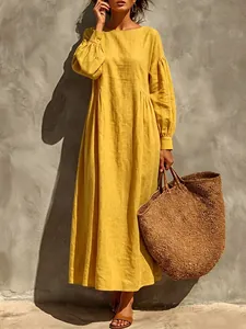 Full-body view of a yellow resort maxi dress styled with a woven bag and sandals