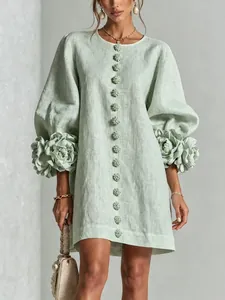 Detail view of light green linen dress featuring 3D floral cuffs and lantern sleeves