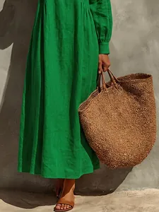 Detail of a vibrant green long sleeve loose maxi dress with a vacation resort vibe