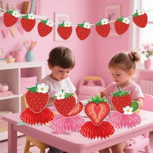 Strawberry themed party supplies with decorative banner and honeycomb centerpieces for girls room