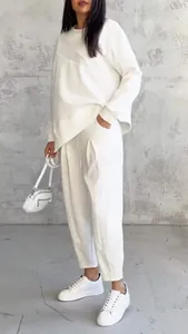 Detail view of women's white loose asymmetrical sweatshirt and matching pants set.