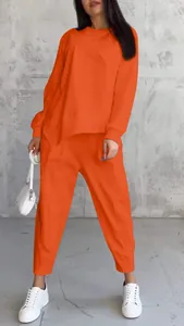 Two-piece orange lounge set featuring a loose irregular sweatshirt and matching pants.