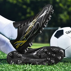 Crampons de football noirs pour hommes avec motif flamme jaune sur terrain d'herbe