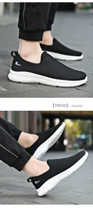Close-up of breathable black fly-knit mesh slip-on sneakers with white soles.