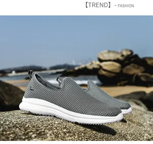 Close-up detail of breathable grey mesh slip-on sneakers presented in a beach setting