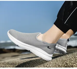 Close-up of breathable grey mesh slip-on shoes for men with thick white non-slip soles.