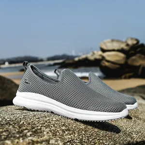 Grey breathable mesh slip-on sneakers for men and women on outdoor rocks