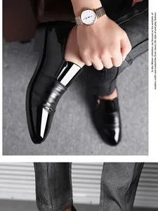 Close-up detail of black patent leather men's slip-on formal shoes with pointed toe