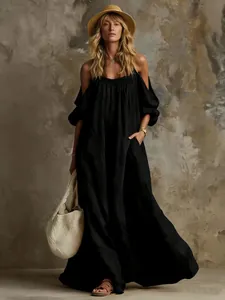 Dettaglio di un abito lungo boho nero in cotone e lino con spalle scoperte stile vacanza
