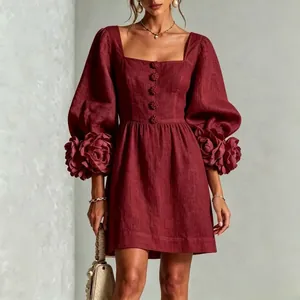 Detaillierte Ansicht der 3D-Blumenmanschetten an einem weinroten französischen Minikleid