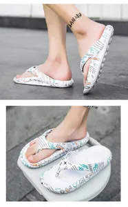 Detailansicht der weißen Flip-Flops mit modischem Graffiti-Print und Herzmustern