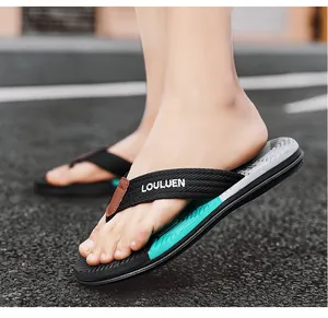 Primo piano di eleganti infradito da uomo all'aperto con logo LOULUEN e suola color acqua