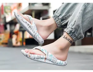 Nahaufnahme modischer weißer Flip-Flops mit buntem Graffiti-Muster für den Sommerstrand
