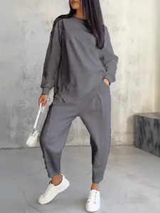Women's minimalist grey two-piece lounge set with irregular hem sweatshirt and joggers.