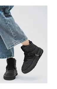 Vista dettagliata di eleganti sneaker alte nere indossate con jeans su sfondo bianco