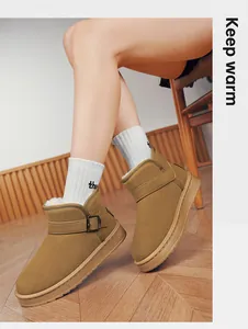 Detail shot of stylish camel snow boots with buckle strap and warm faux fur lining.