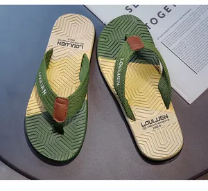 Dettaglio delle infradito da uomo con motivo geometrico verde e beige estivo.