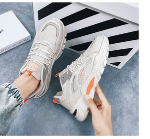 Vista dettagliata di sneaker chunky in mesh grigio traspirante con vivaci accenti arancioni