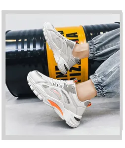Vista laterale di sneakers dad bianche in mesh traspirante con dettagli arancioni per l'esterno