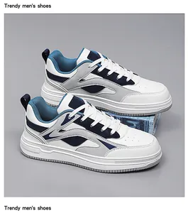 Detailed view of trendy men's white and navy chunky sneakers on a neutral grey background
