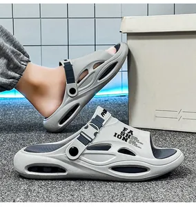 Detailansicht grauer Herren-Clogs mit dicker Sohle und modischen schwarzen Riemenakzenten.