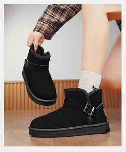 Detail view of black suede snow boots with buckle strap and warm faux fur lining.