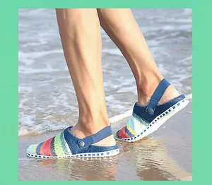 Dichtbij opname van regenboog strandsandalen gedragen op een zandstrand